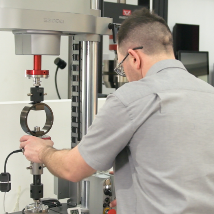 Instron technician performing calibration on a universal testing system. | Instron