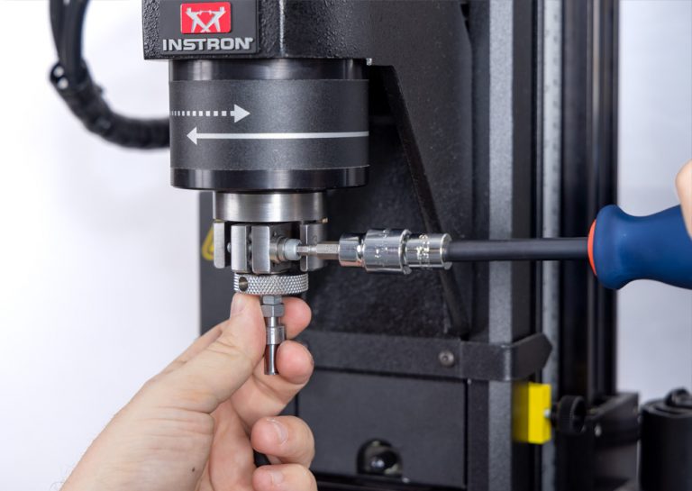 Technician adjusting alignment on the Instron Torsion Add-On 3.0 for improved concentricity